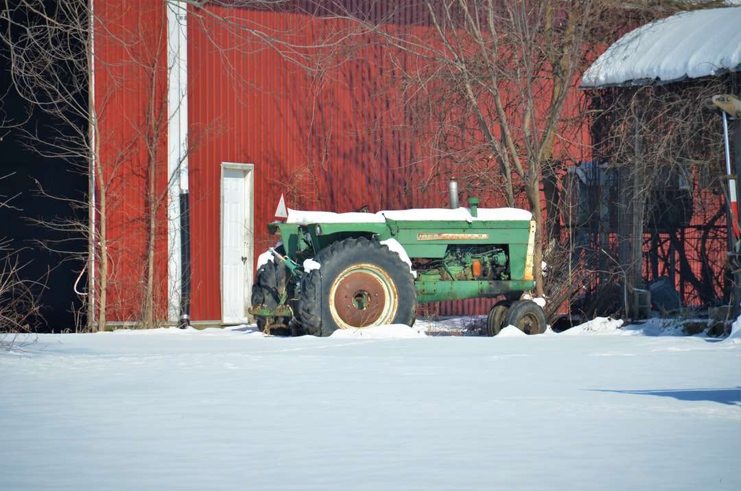 zielony i czarny traktor na ziemi pokrytej śniegiem puzzle online
