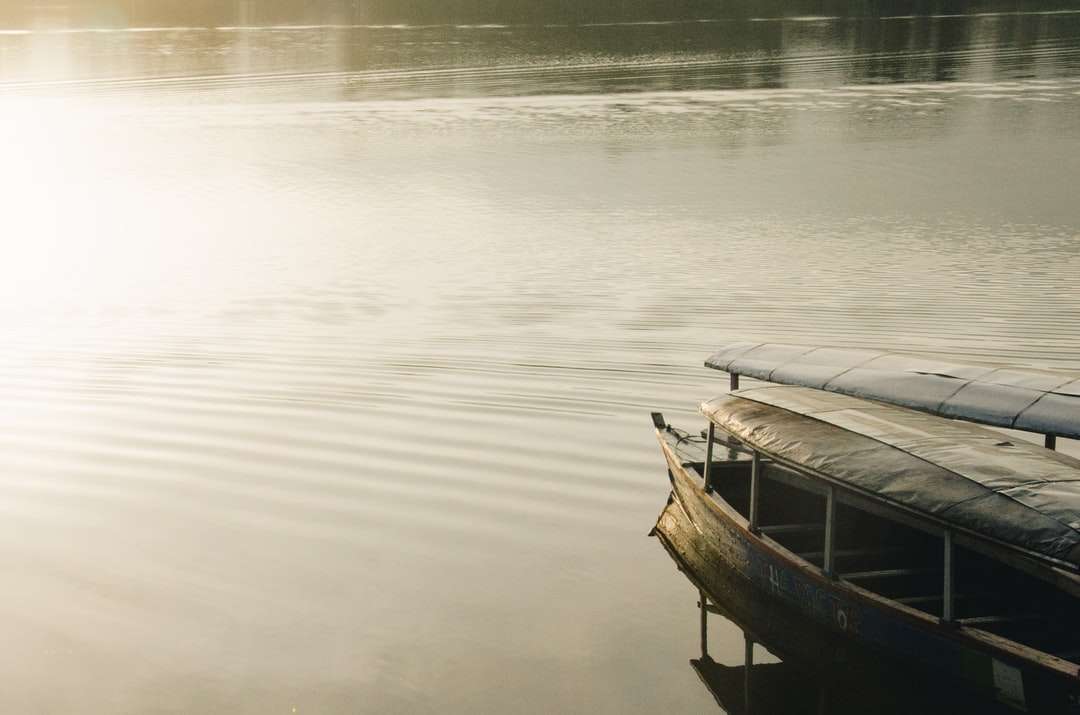 brązowa drewniana łódź na spokojnej wodzie w ciągu dnia puzzle online