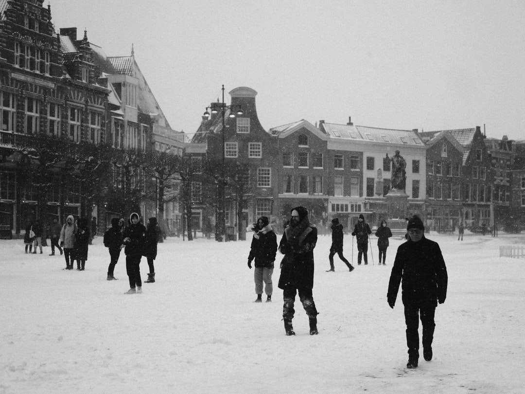 ludzie chodzą po ziemi pokrytej śniegiem w pobliżu budynku puzzle online