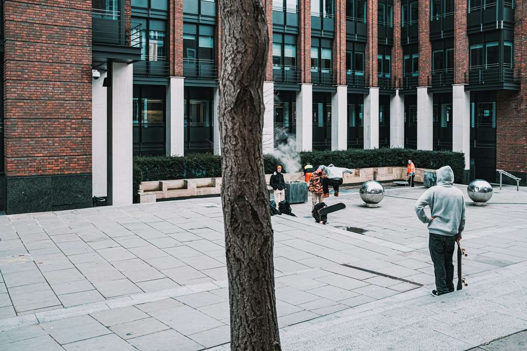 ludzie chodzą po chodniku w pobliżu brązowych nagich drzew puzzle online