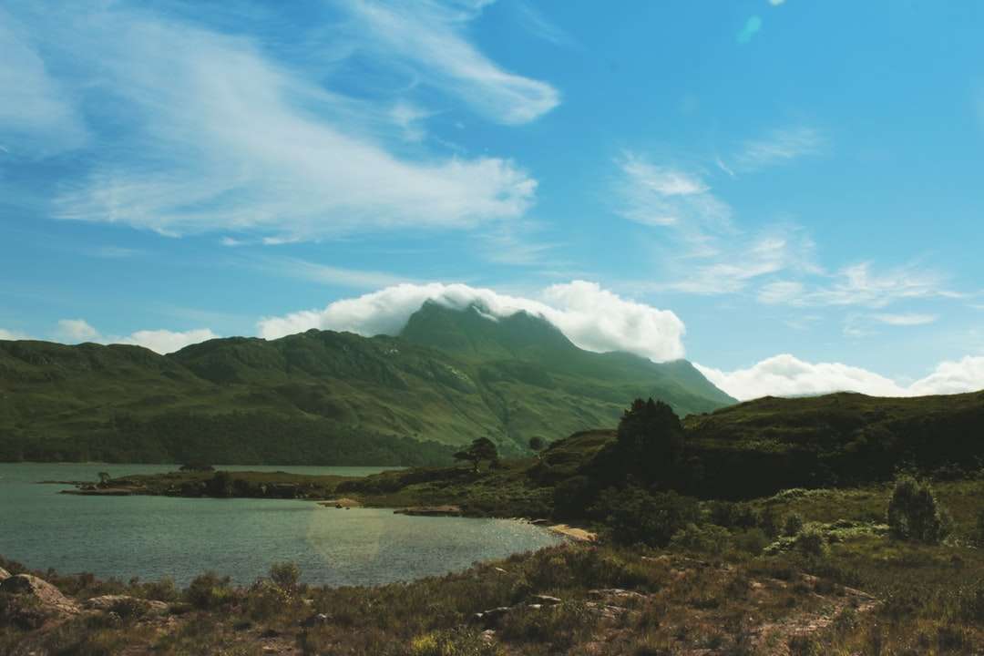 zielone góry w pobliżu akwenu pod błękitnym niebem puzzle online