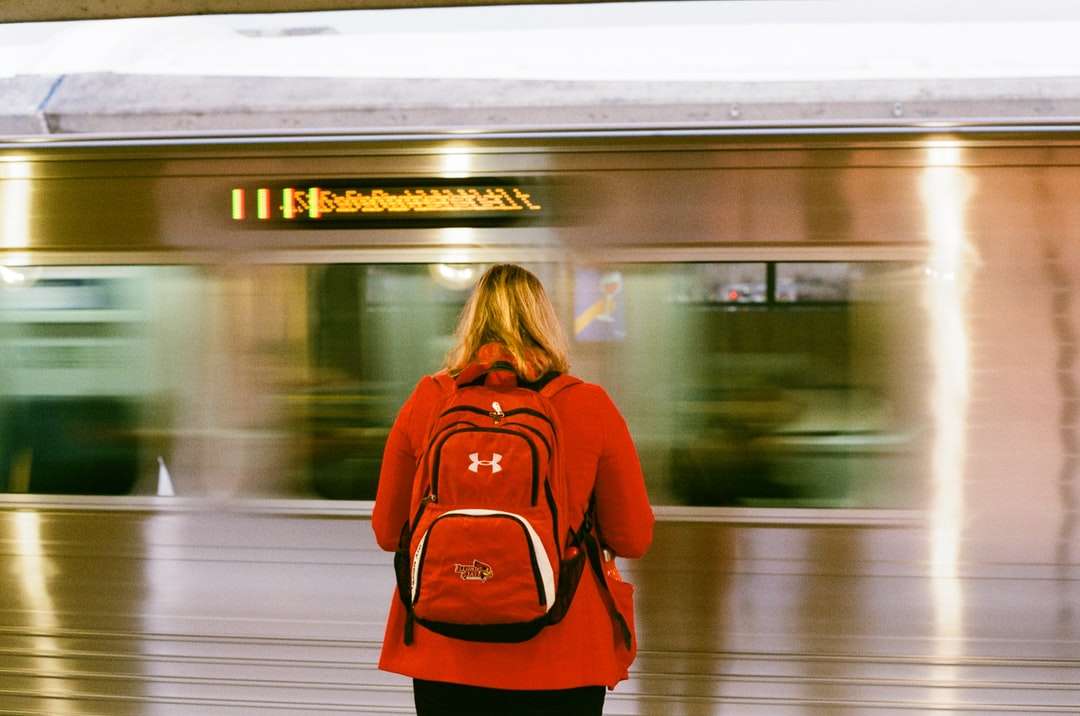kobieta w czerwonej koszuli z długim rękawem stojącej przed pociągiem puzzle online