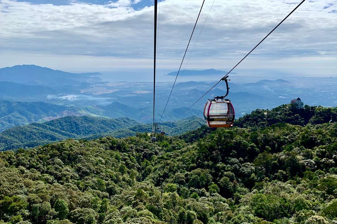 brązowa kolejka linowa nad zielonymi górami w ciągu dnia puzzle online