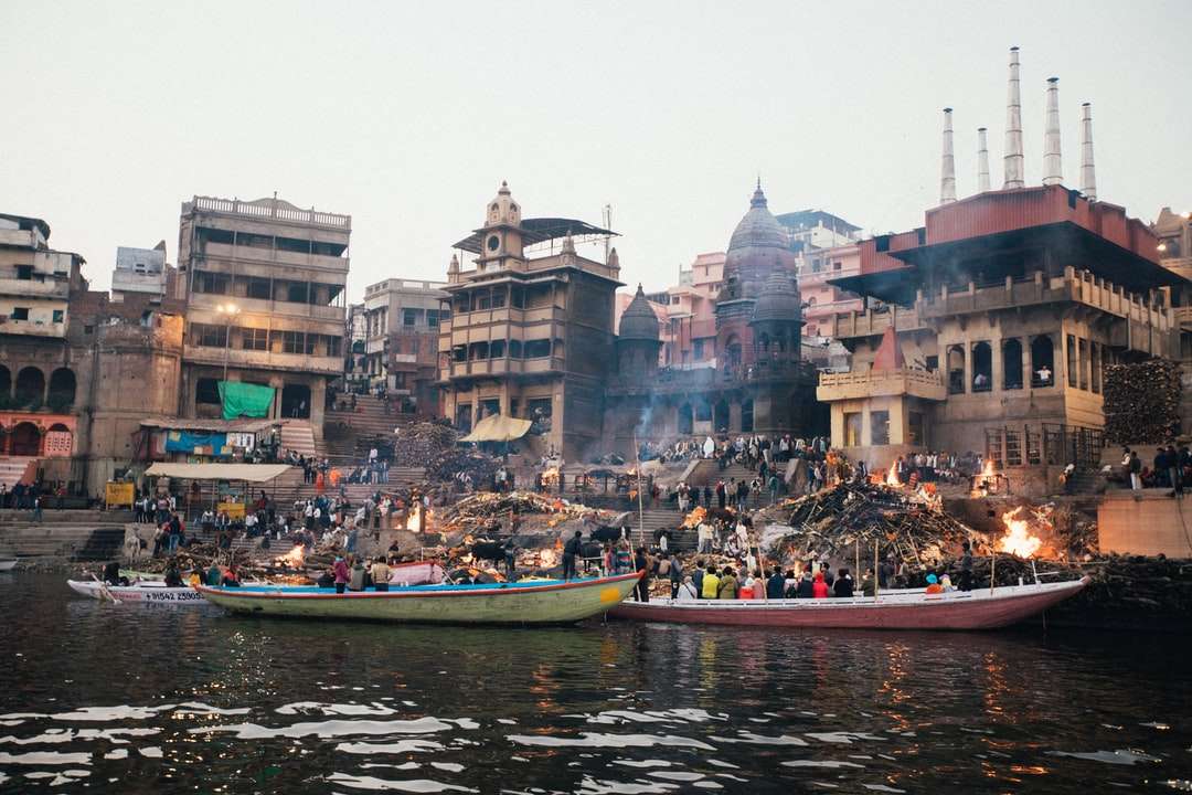 ludzie jadący łodzią po rzece w pobliżu budynków w ciągu dnia puzzle online