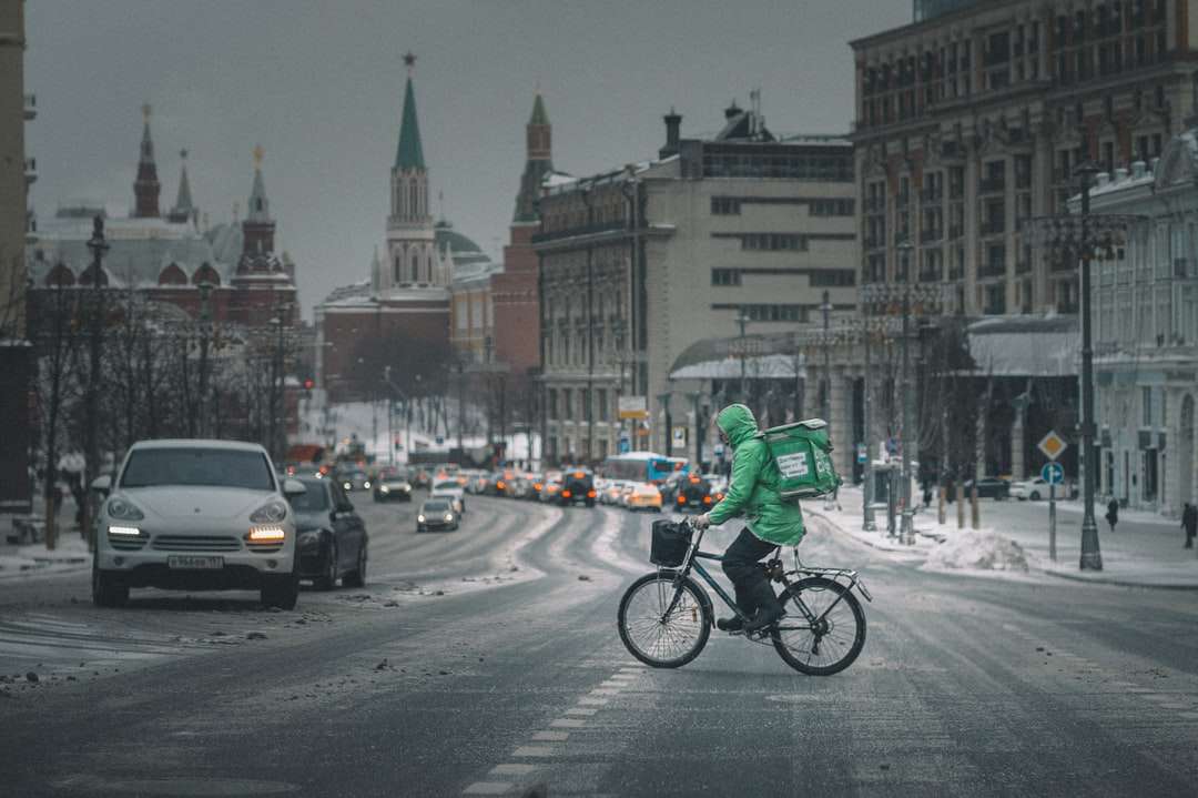 człowiek w zielonej kurtce, jazda na rowerze na drodze w ciągu dnia puzzle online