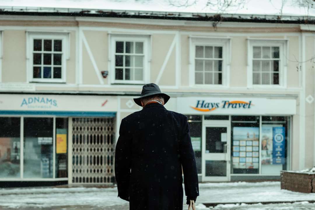 mężczyzna w czarnym płaszczu chodzenie po ziemi pokrytej śniegiem puzzle online