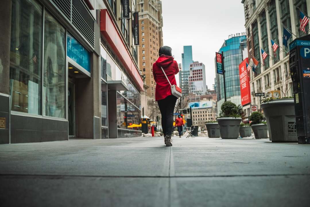 mężczyzna w czerwonej kurtce i czarnych spodniach chodzenia po chodniku puzzle online