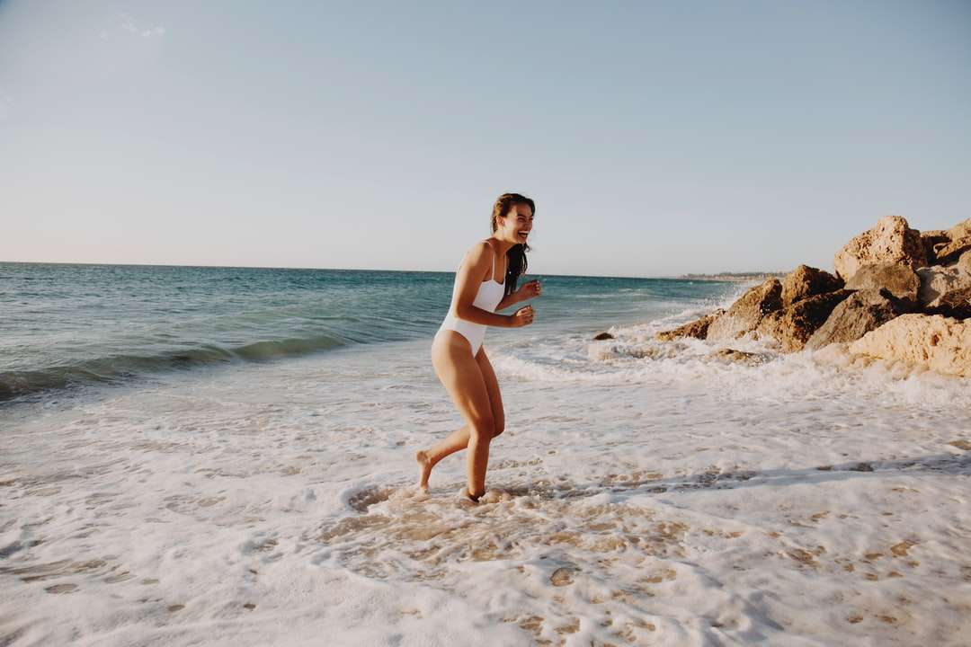 kobieta w białym bikini stojąc na plaży w ciągu dnia puzzle online