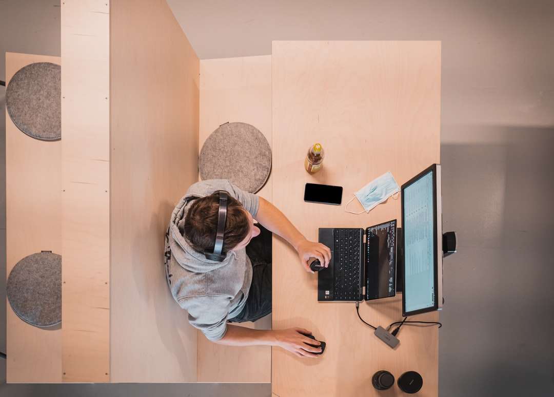 kobieta w niebieskiej koszuli siedzi na krześle przy użyciu komputera przenośnego puzzle online