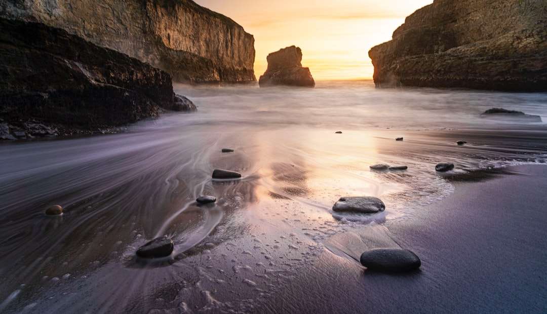 brązowa formacja skalna na brzegu morza w ciągu dnia puzzle online