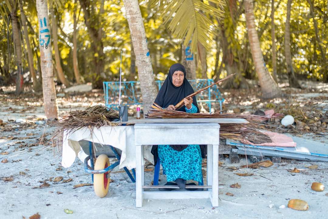 kobieta w czarnym hidżabie siedzi na krześle puzzle online