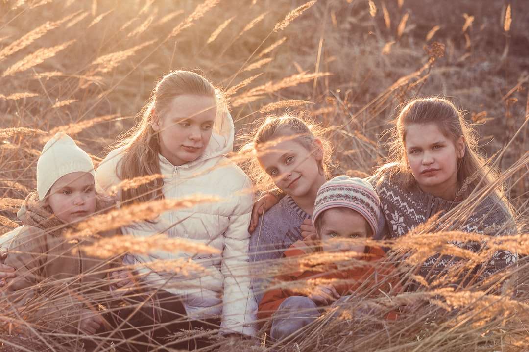 3 dziewczynki leżące w ciągu dnia na wyschniętej brązowej trawie puzzle online