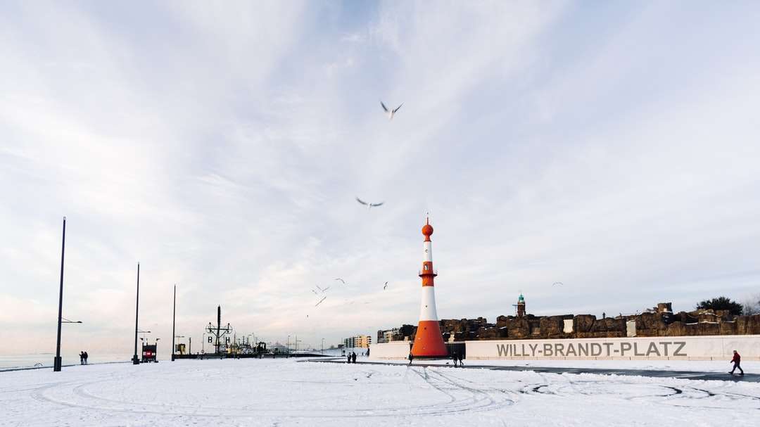 brązowo-biała latarnia morska na ziemi pokrytej śniegiem puzzle online
