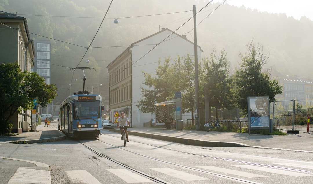niebieski i biały tramwaj na drodze w pobliżu budynku w ciągu dnia puzzle online