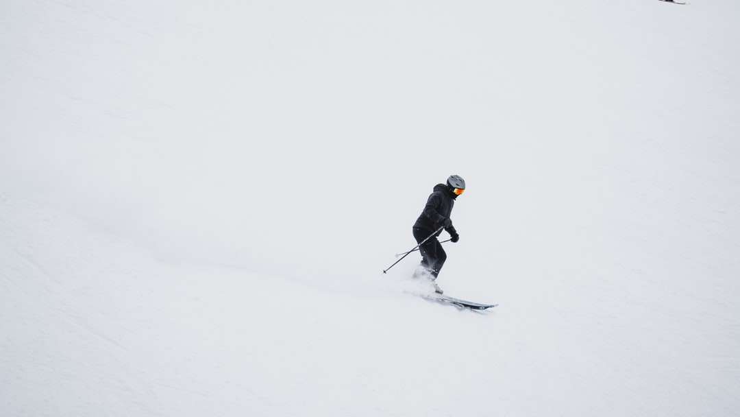 mężczyzna w czarnej kurtce i czarnych spodniach, jeżdżący na nartach puzzle online