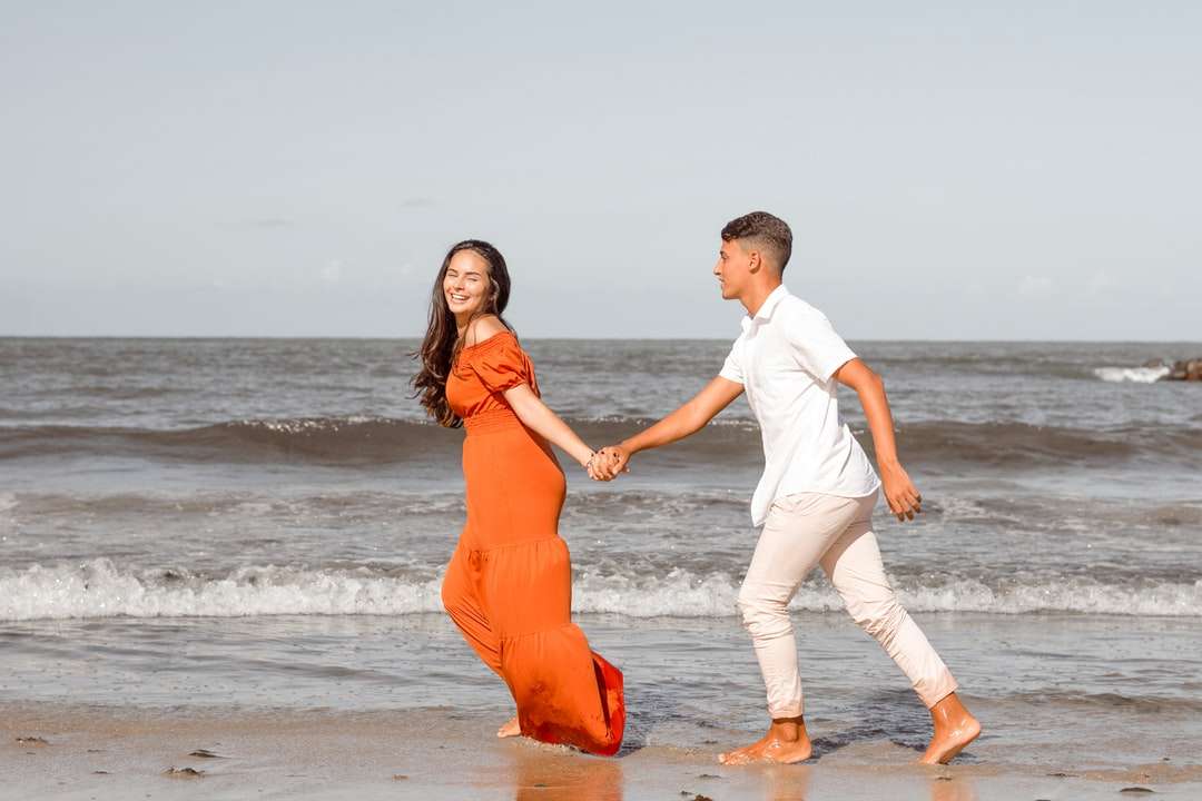 mężczyzna i kobieta w białej koszuli z długim rękawem i pomarańczowej sukience puzzle online