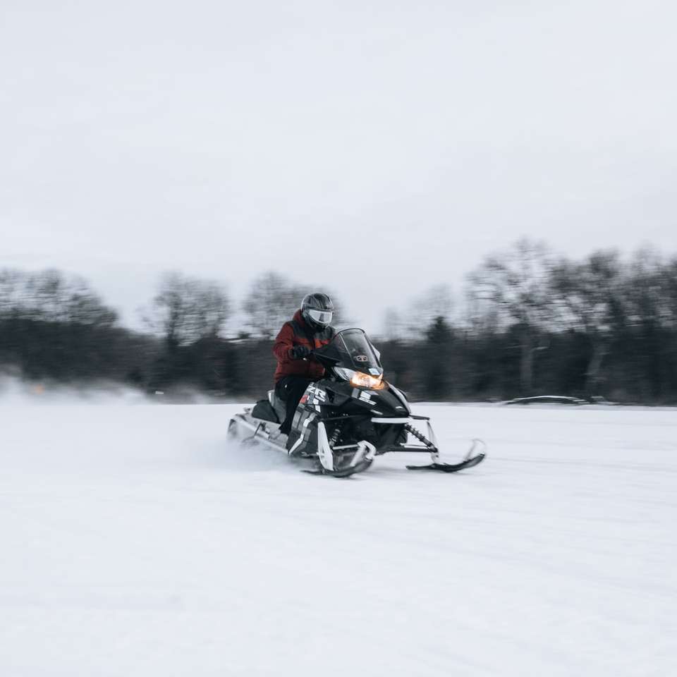 mężczyzna jedzie na czarnym motocyklu na polu pokryte śniegiem puzzle online