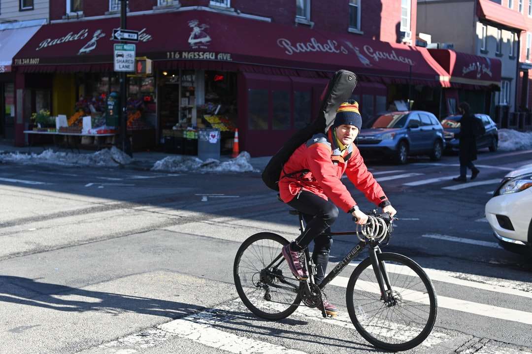 mężczyzna w czerwonej kurtce, jazda na rowerze w ciągu dnia puzzle online