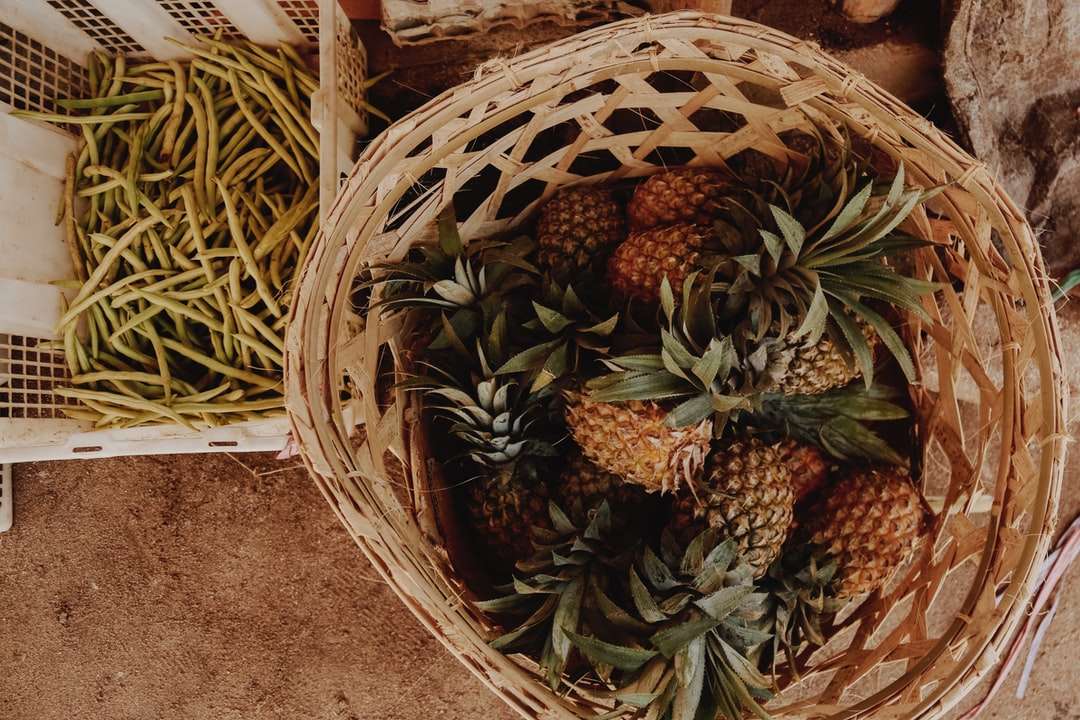 brązowy i zielony owoc ananasa na brązowym plecionym koszu puzzle online