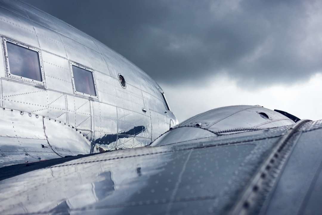 biały samolot pod zachmurzonym niebem w ciągu dnia puzzle online
