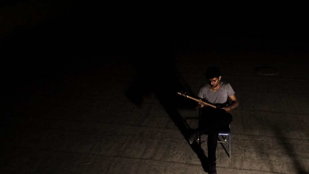 mężczyzna w szarej koszulce z okrągłym dekoltem gra na gitarze puzzle online