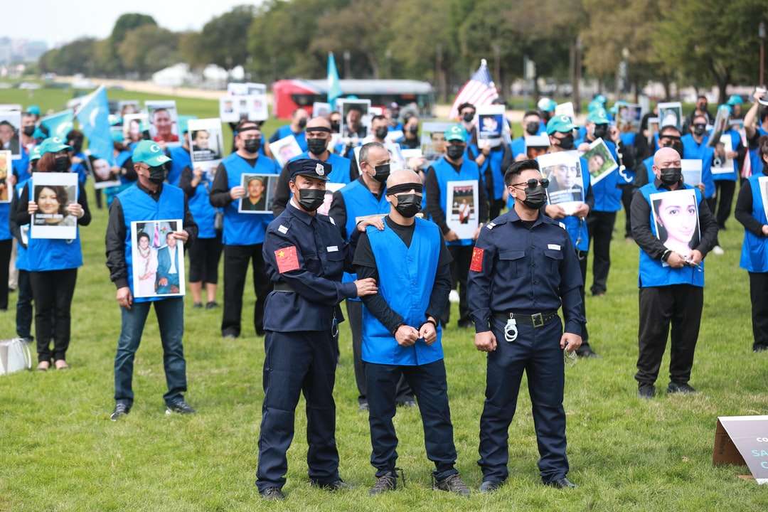 mężczyzna w niebieskim mundurze policyjnym stojący na polu zielonej trawie puzzle online