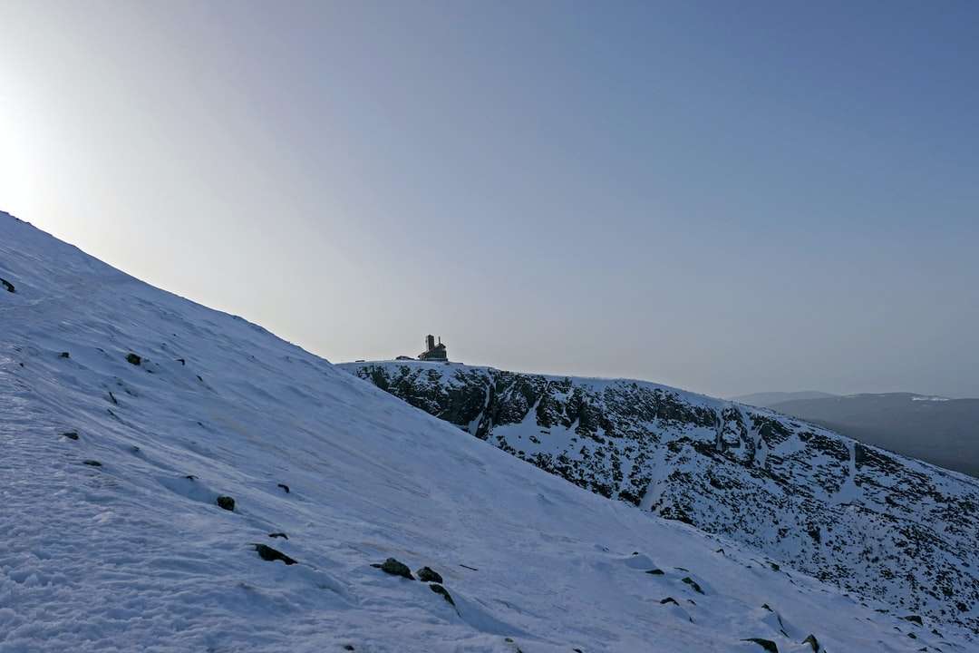 osoba stojąca na zaśnieżonej górze w ciągu dnia puzzle online