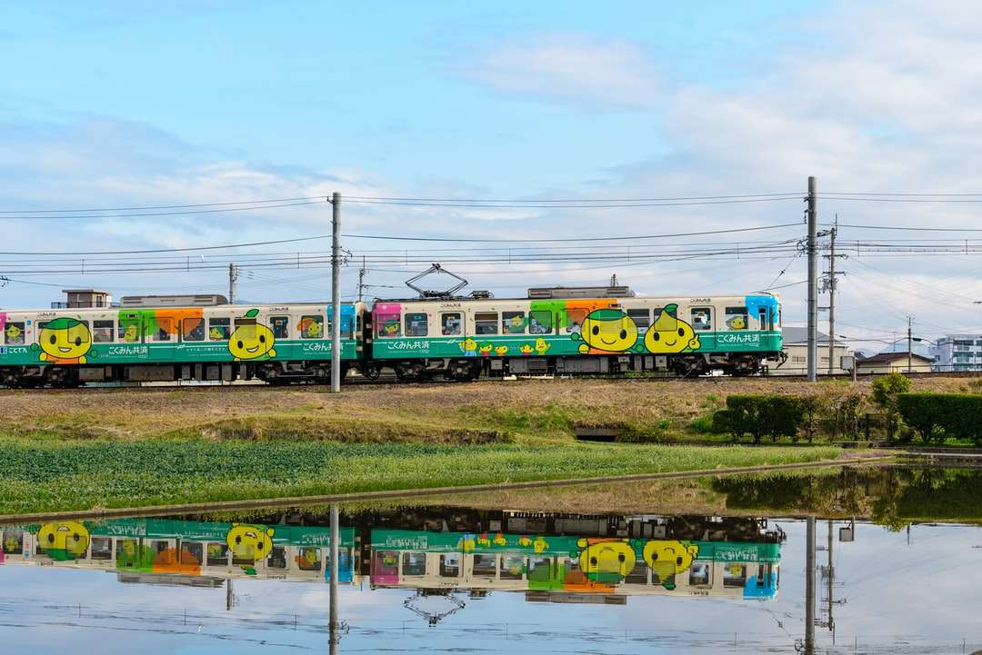 niebieski żółty i czerwony pociąg na torach kolejowych w ciągu dnia puzzle online