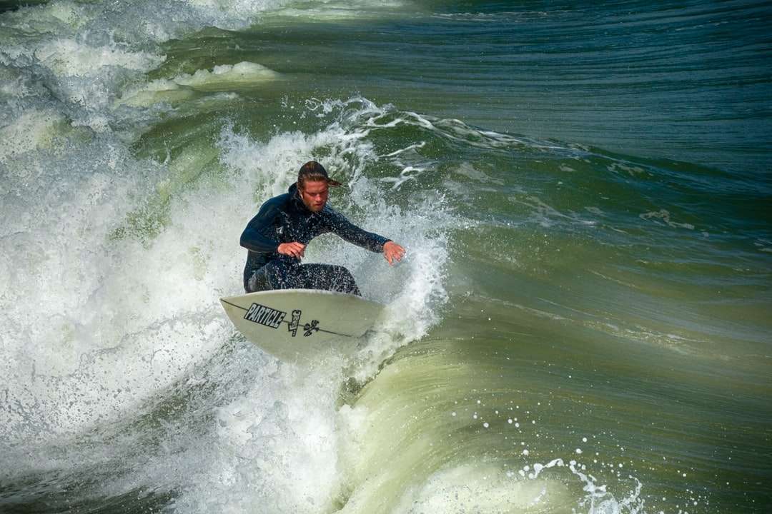 mężczyzna w czarnej i czerwonej kurtce, surfing na falach morskich puzzle online