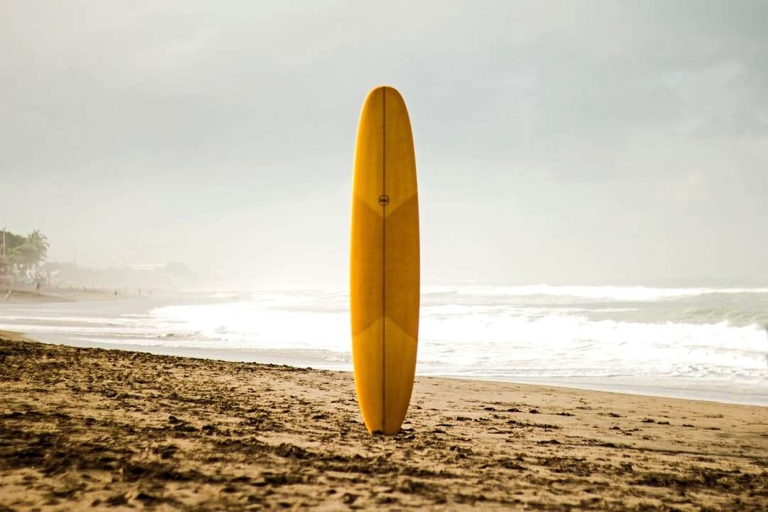 żółta deska surfingowa na plaży w ciągu dnia puzzle online