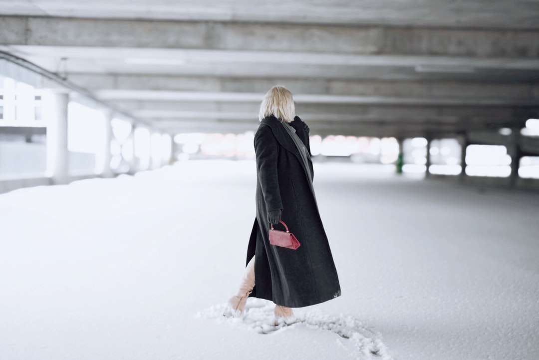 kobieta w czarnym płaszczu stojąc na ziemi pokryte śniegiem puzzle online