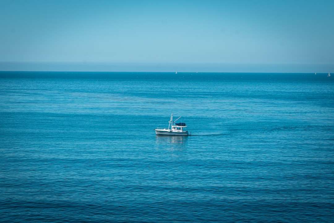 biała łódź na błękitnym morzu pod błękitnym niebem w ciągu dnia puzzle online