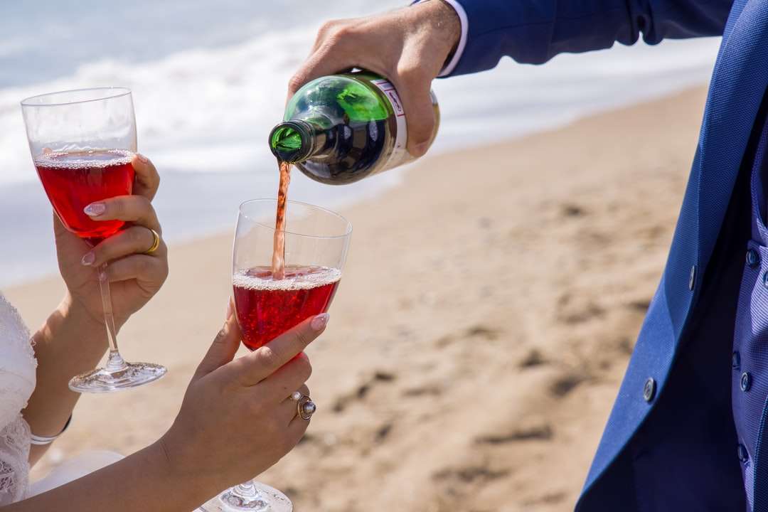 2 osoby trzymające szklanki na plaży w ciągu dnia puzzle online
