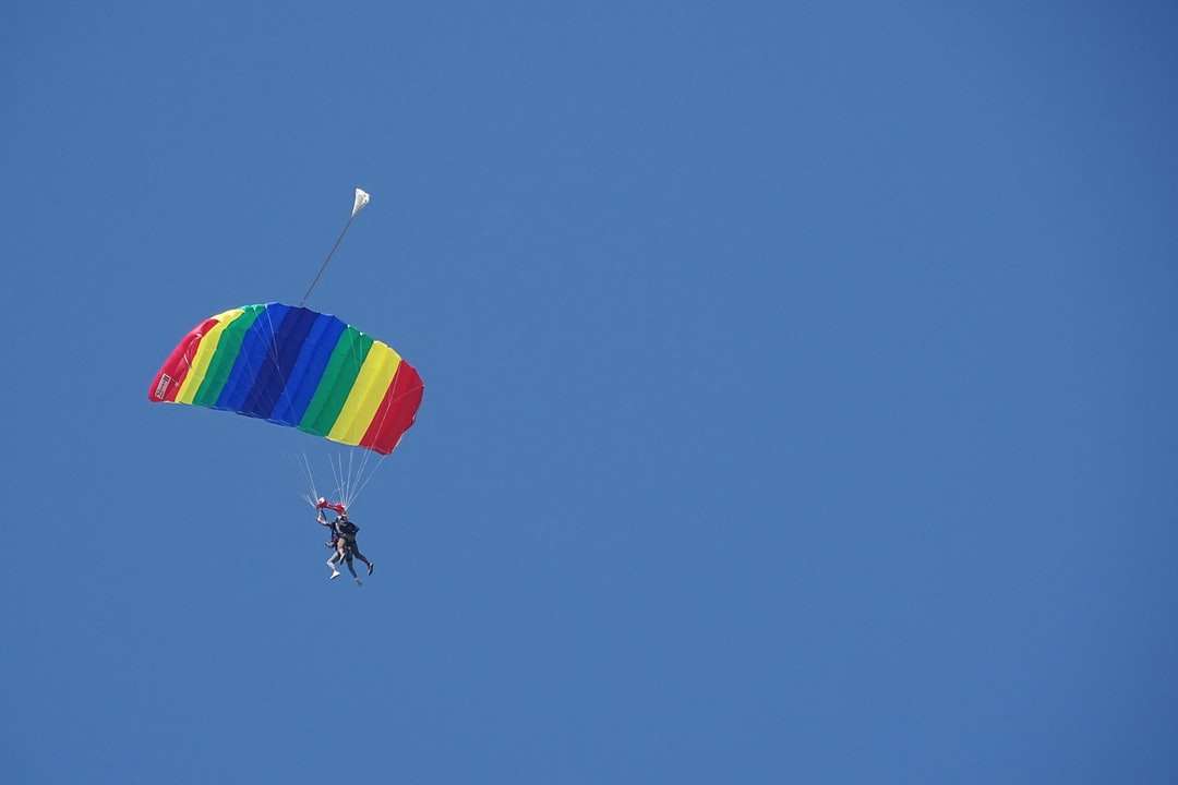 osoba w spadochronie pod błękitnym niebem w ciągu dnia puzzle online
