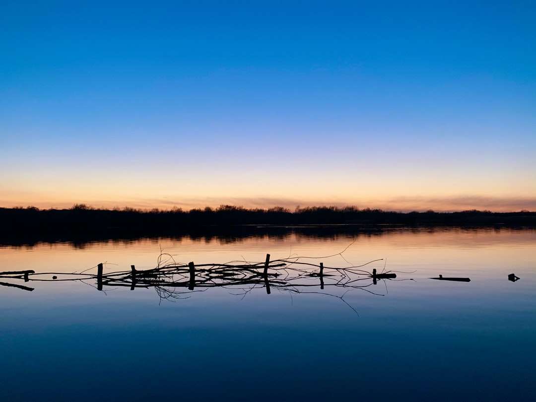 brązowy drewniany płot nad jeziorem podczas zachodu słońca puzzle online