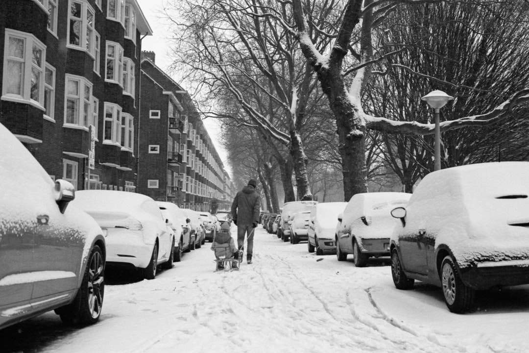 człowiek w czarnej kurtce chodzenia po zaśnieżonej drodze puzzle online