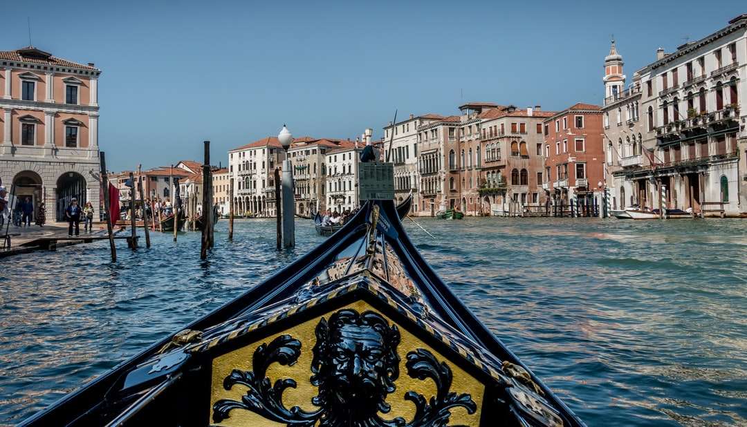 łódź na wodzie w pobliżu budynków w ciągu dnia puzzle online