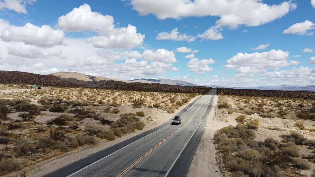szara droga asfaltowa pod błękitne niebo w ciągu dnia puzzle online