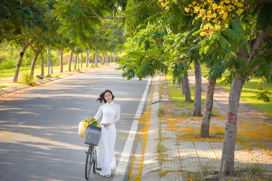 kobieta w białej koszuli z długim rękawem, jazda na rowerze na drodze puzzle online