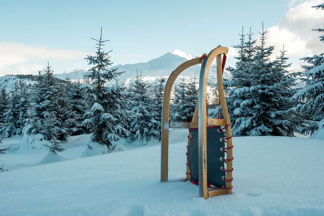 brązowe drewniane sanki śnieżne na ziemi pokrytej śniegiem w ciągu dnia puzzle online