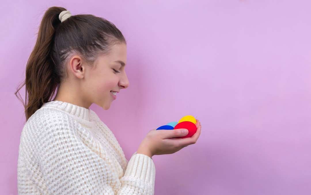 Kobieta w białym dzianina sweter trzyma błękitną piłkę puzzle online