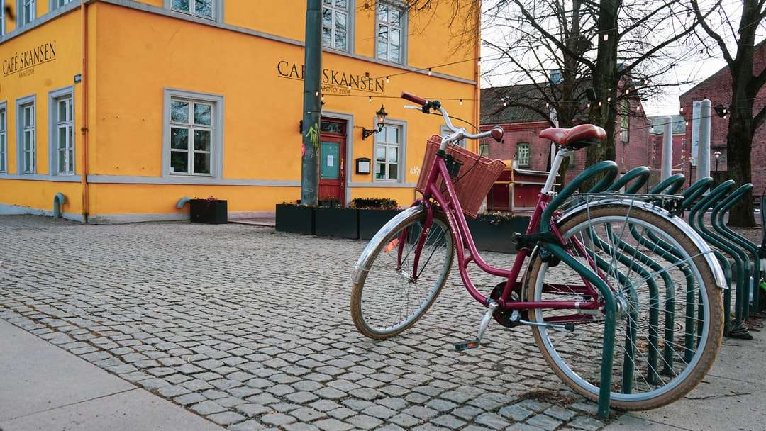 Czerwony rower miasto zaparkowany obok brown betonowego budynku puzzle online