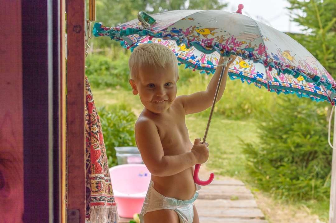 Topless Baby Holding Parasol podczas siedzenia puzzle online