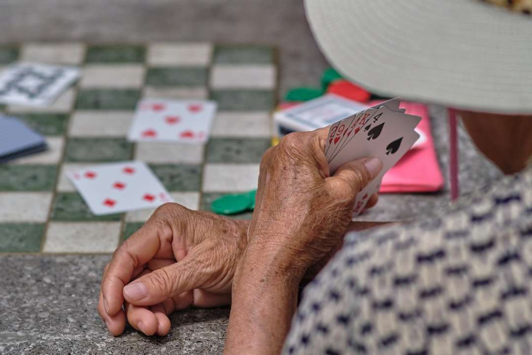 osoba posiadająca białe i czarne karty do gry puzzle online