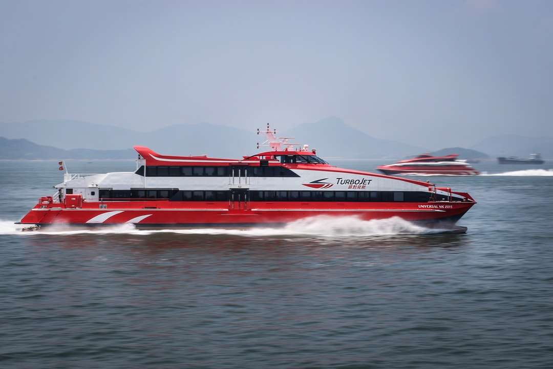 Czerwona i biała łódź pasażerska na wodzie w ciągu dnia puzzle online