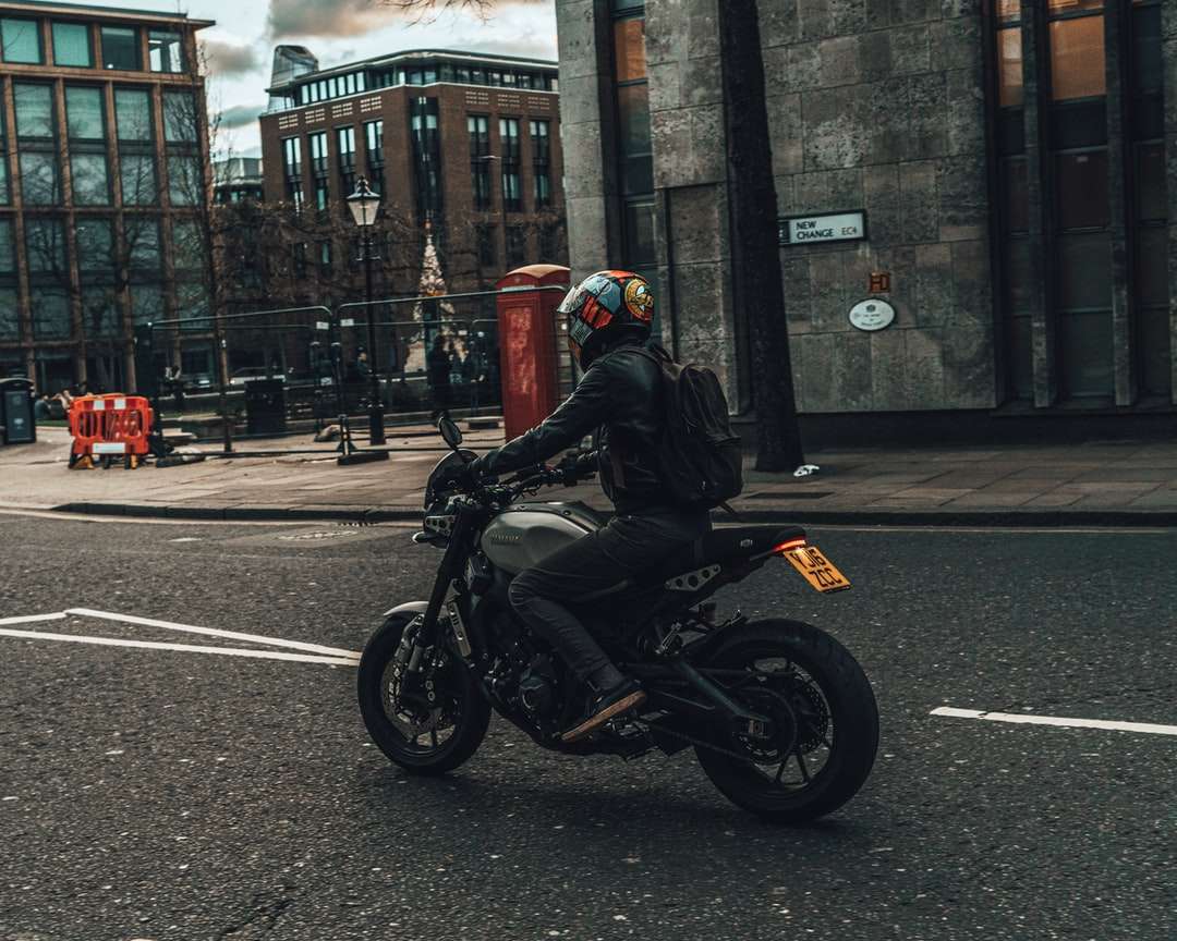 Omul în motocicleta de motocicletă neagră pe motocicletă pe drum puzzle
