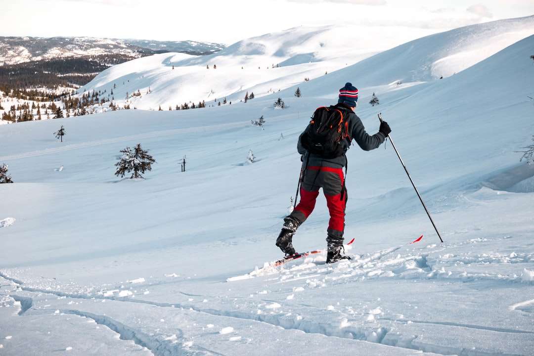 Człowiek w czarnej kurtce i czarne spodnie jeździć na nartach puzzle online