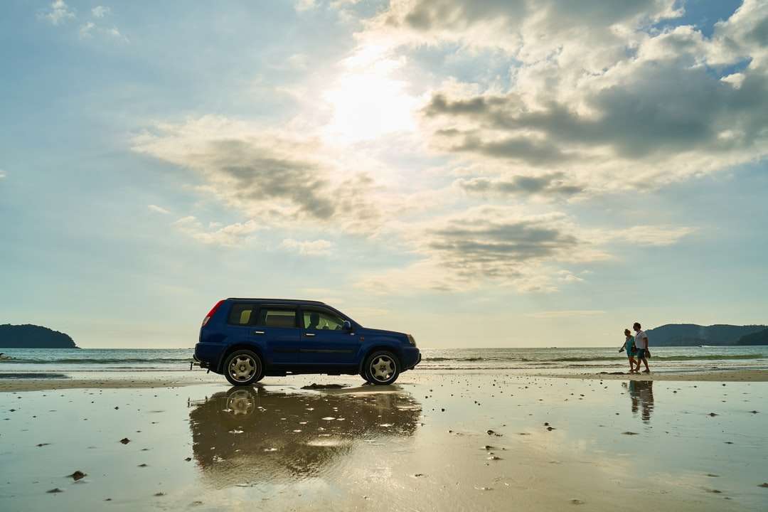 Niebieski SUV na plaży w ciągu dnia puzzle online