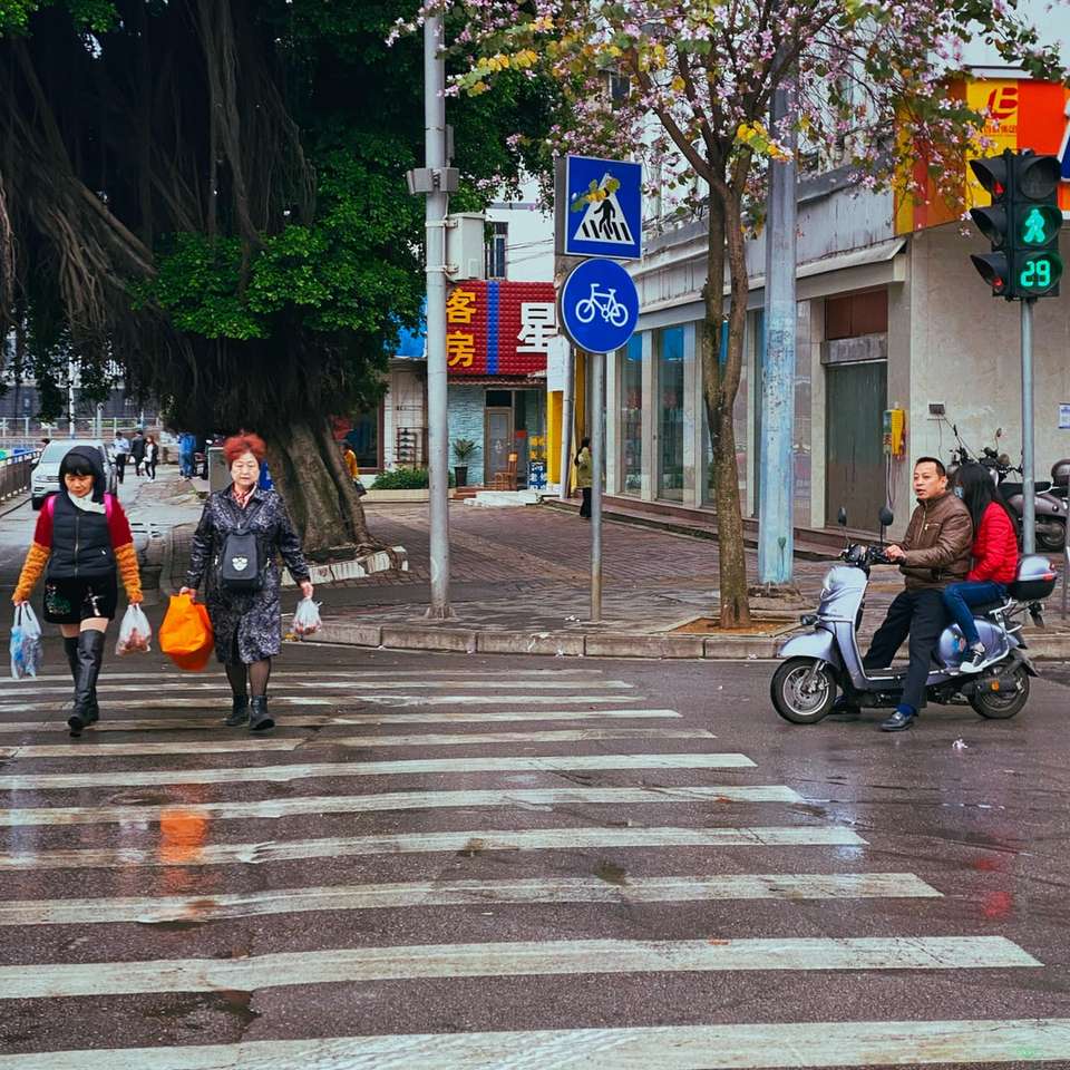 Ludzie jeżdżący motocyklem na pasie dla pieszych w ciągu dnia puzzle online