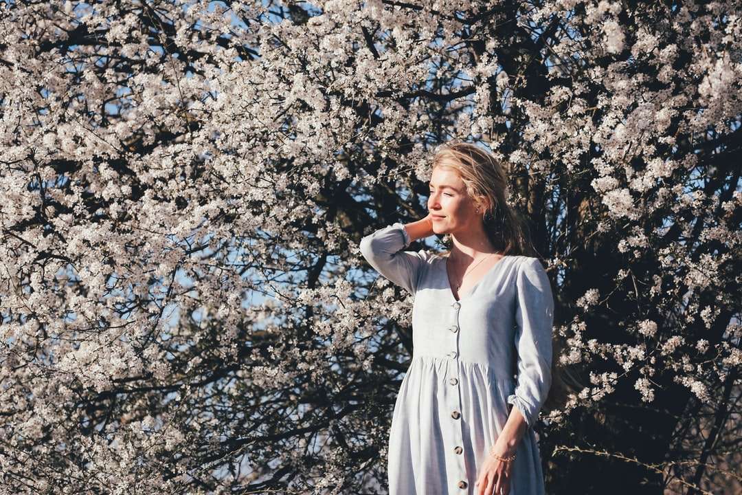 Kobieta w białej sukni stoi blisko białych kwiatów puzzle online